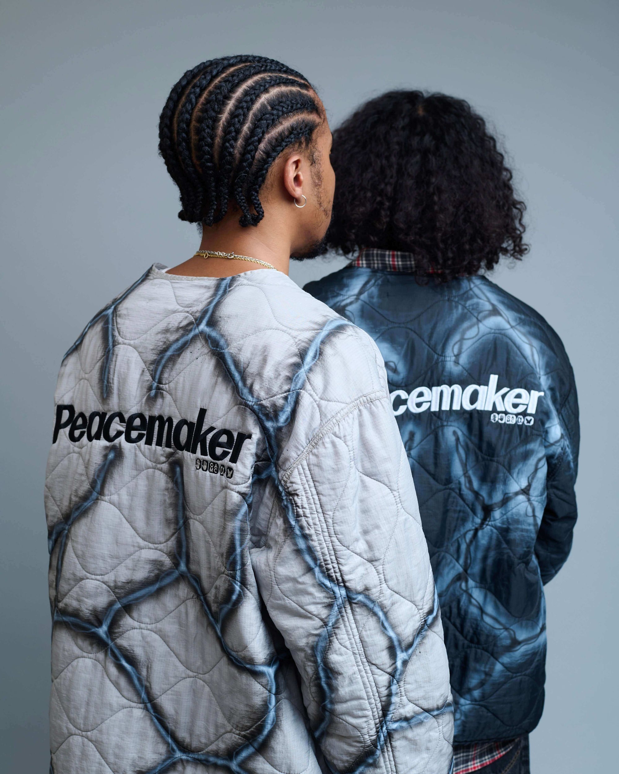 Travis Spinks Custom Painted Combat Liner worn by two models showcasing Peacemaker embroidery