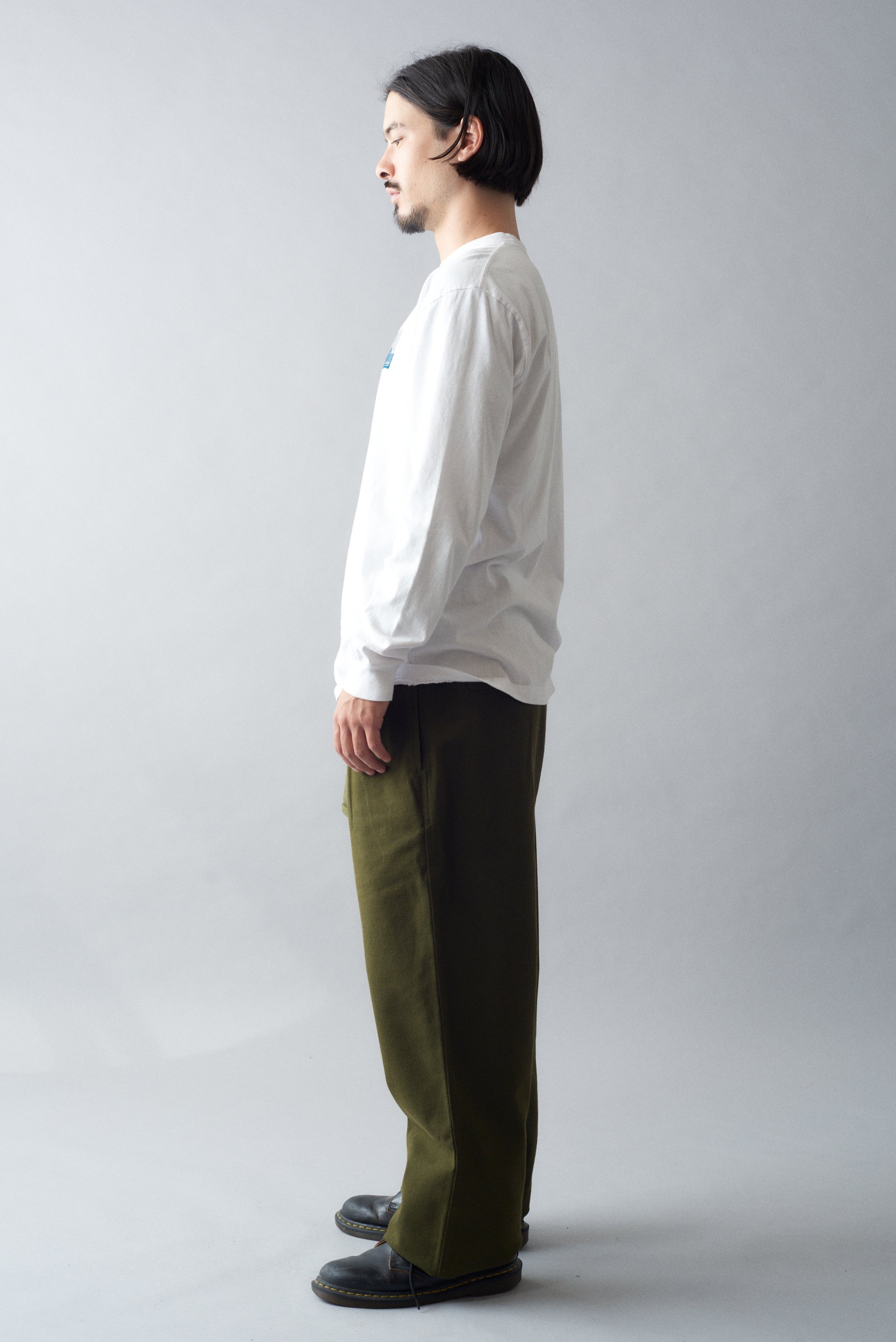 Man wearing MHL Cotton Wool Drill Slide Adjuster Trouser with a white shirt, standing sideways on a neutral background