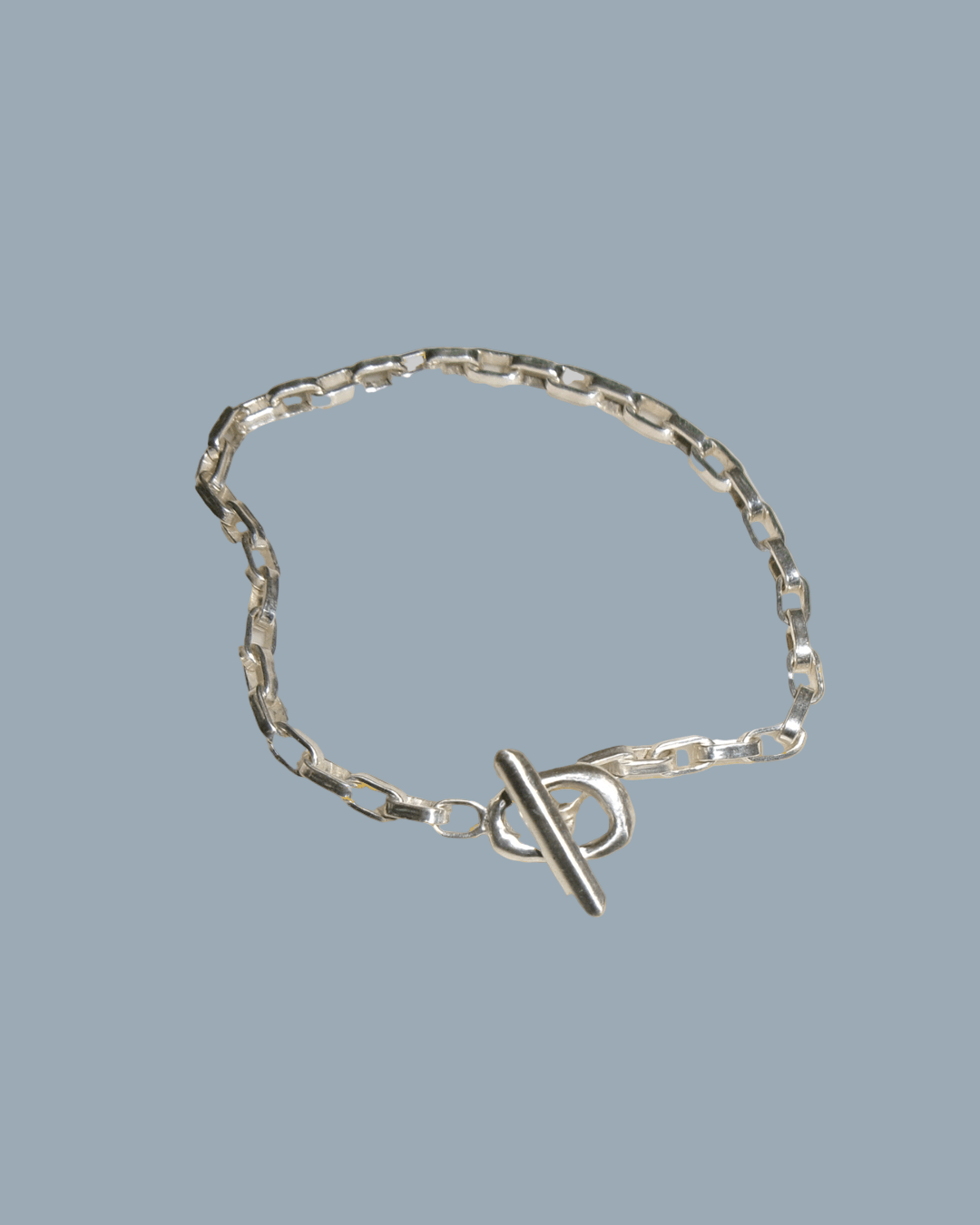 Silver chain bracelet with a clasp on a gold background