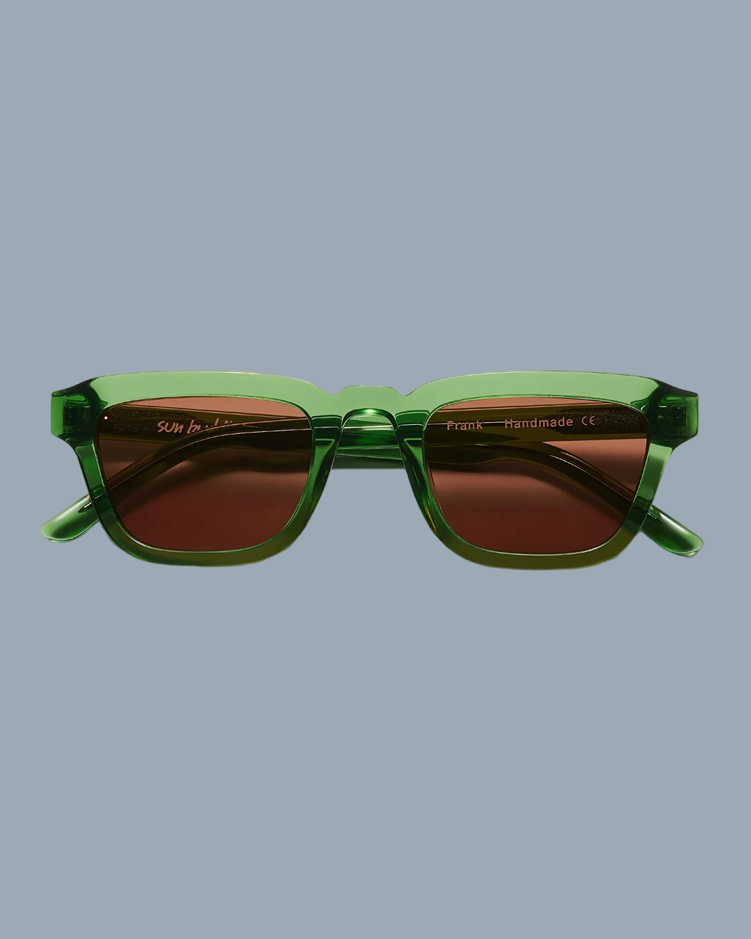 Green sunglasses with brown lenses on a yellow background