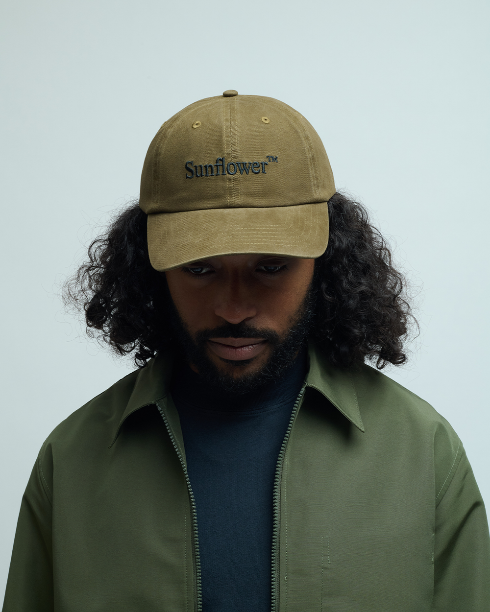 Olive washed twill cap with embroidered Sunflower logo on front panel, curved brim, adjustable strap back
